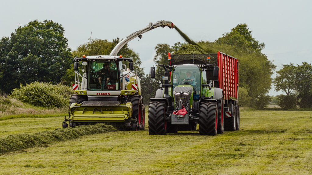 Zwei Maschinen auf einem Feld, die Gras häckseln
